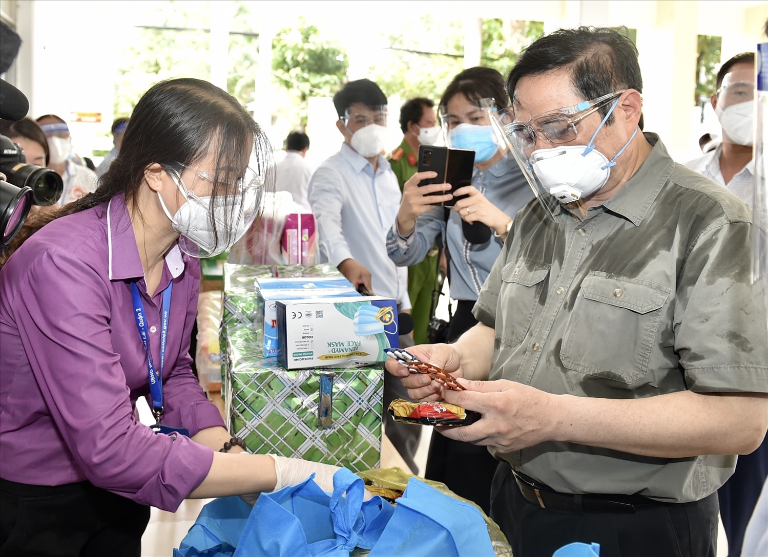 Thủ tướng xem các loại nhu yếu phẩm, thuốc men... trong túi an sinh sẽ được cung cấp cho người dân. Ảnh: VGP/Nhật Bắc Thủ tướng xem các loại nhu yếu phẩm, thuốc men... trong túi an sinh sẽ được cung cấp cho người dân. Ảnh: VGP/Nhật Bắc
