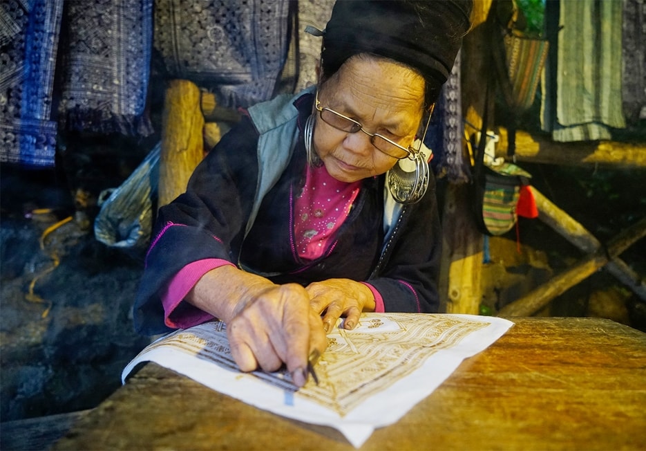 Vẽ sáp ong để in họa tiết hoa văn cho vải