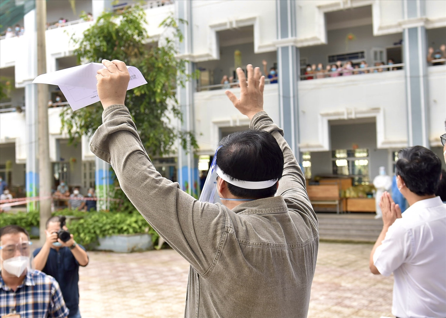 Thủ tướng vẫy chào, động viên bà con đang thực hiện cách ly tập trung tại Trường Tiểu học Bình Thuận, phường Thuận Giao, TP. Thuận An. Ảnh: VGP/Nhật Bắc