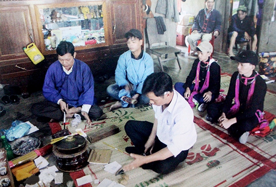 Nghi lễ trước bàn thờ Nhị Nguyên trong lễ cấp sắc trước khi đi trả lễ cho cha mẹ nuôi, hoặc họ cha mẹ của người Dao ở xã Thanh Sơn, huyện Định Quán. (Ảnh tư liệu)
