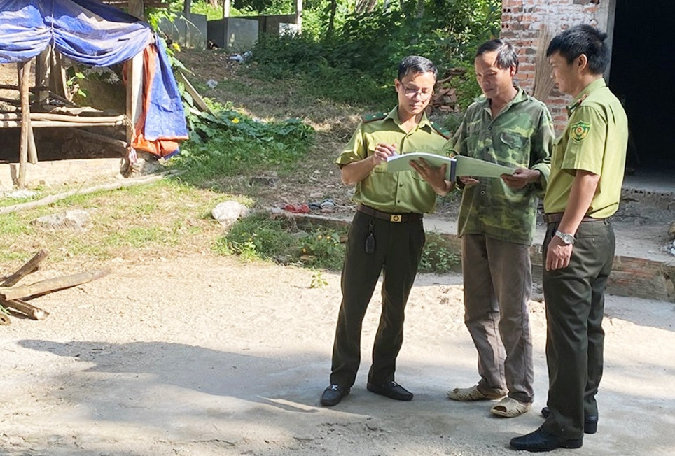 Cán bộ kiểm lâm Trạm Kiểm lâm Minh Quang tuyên truyền gia đình anh Dư Văn Tám ở thôn Quang Minh, xã Minh Quang không xây dựng nhà, cơi nới chuồng trại trong khu vực rừng đặc dụng. (Ảnh chụp trước ngày 27/4/2021)