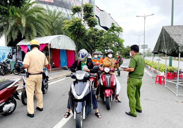 Lực lượng Công an tại chốt kiểm tra trên đường Phạm Văn Đồng (phường Hiệp Bình Chánh, Thủ Đức) kiểm tra giấy tờ của người lưu thông. Ảnh: TTXVN