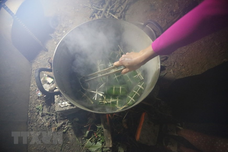 Sau khi gói xong, xếp bánh vào nồi, lót lá dong xuống đáy và trên cùng để không bị cháy và giữ được hơi. Bánh được luộc trong khoảng 12-15 giờ, sau khi luộc xong, rửa bánh trong nước lạnh cho sạch nhựa, để ráo hoặc túm lại treo lên. (Ảnh: Trọng Đạt/TTXVN)