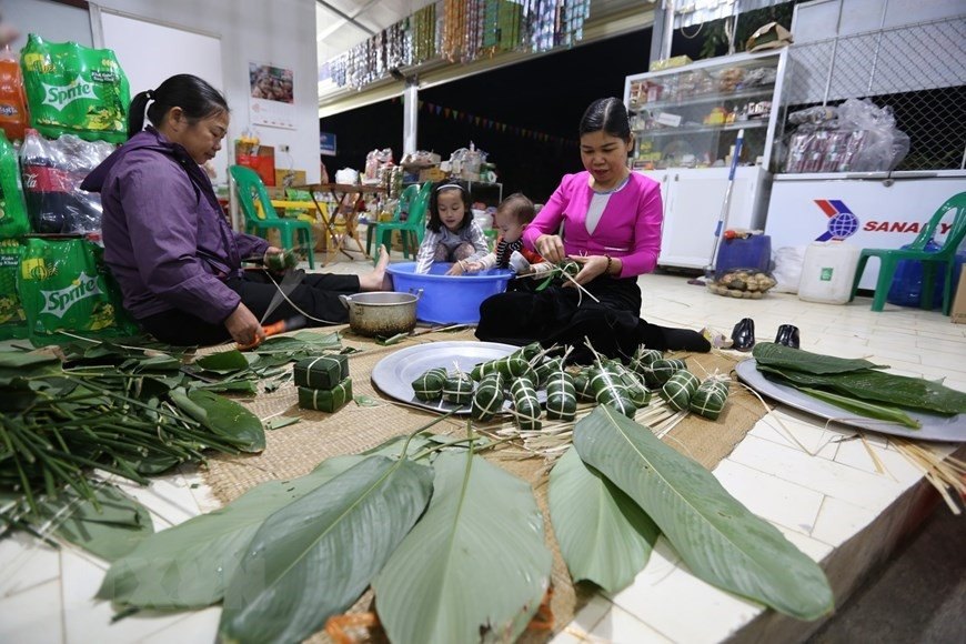 Vào ngày gói bánh, con cháu quây quần bên mâm bánh. Mỗi người mỗi việc, chuẩn bị cũng khá cầu kỳ. (Ảnh: Trọng Đạt/TTXVN)
