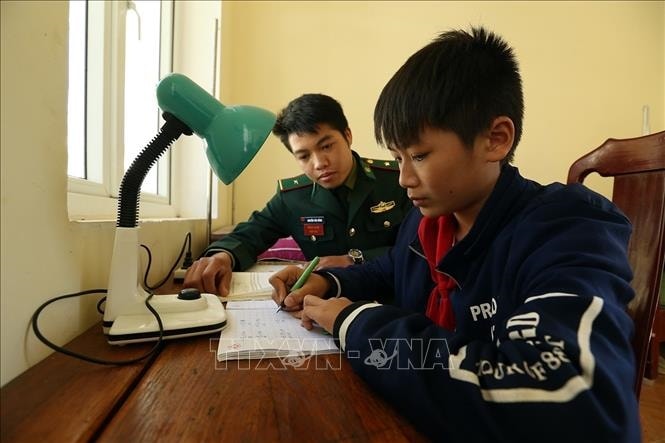 Chiến sỹ đồn Biên phòng Pa Thơm, tỉnh Điện Biên hướng dẫn cháu Quàng Trung Thành học bài sau giờ lên lớp. Ảnh: Phan Tuấn Anh/TTXVN Chiến sỹ đồn Biên phòng Pa Thơm, tỉnh Điện Biên hướng dẫn cháu Quàng Trung Thành học bài sau giờ lên lớp. Ảnh: Phan Tuấn Anh/TTXVN
