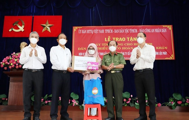 Ông Trương Hòa Bình, nguyên Ủy viên Bộ Chính trị, nguyên Phó Thủ tướng Thường trực Chính phủ, Chủ tịch Danh dự Quỹ Bảo trợ học sinh dân tộc thiểu, học sinh nghèo Báo Công an Nhân dân (thứ hai từ trái sang) trao tặng máy tính bảng cho học sinh dân tộc Chăm có hoàn cảnh khó khăn. 