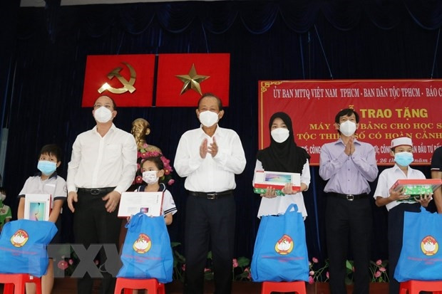 Ông Trương Hòa Bình, nguyên Ủy viên Bộ Chính trị, nguyên Phó Thủ tướng Thường trực Chính phủ, Chủ tịch Danh dự Quỹ Bảo trợ học sinh dân tộc thiểu số, học sinh nghèo Báo Công an Nhân dân (giữa), ông Nguyễn Hồ Hải, Phó Bí thư Thành ủy Thành phố Hồ Chí Minh (thứ 2 từ trái sang) trao tặng máy tính bảng cho các học sinh dân tộc Chăm và Khmer