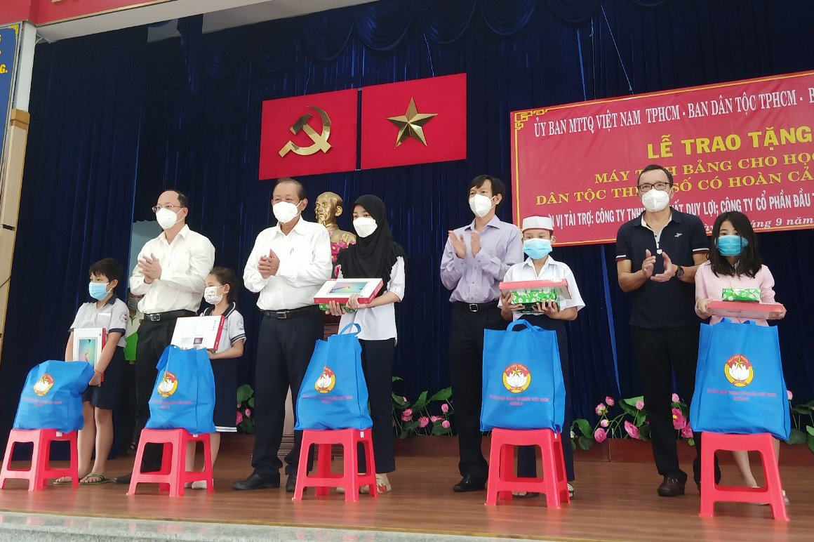 Ông Trương Hòa Bình cùng đại diện lãnh đạo TP. Hồ Chí Minh và đơn vị tài trợ trao máy tính bảng và quà cho đại diện các em học sinh DTTS khó khăn trên địa bàn