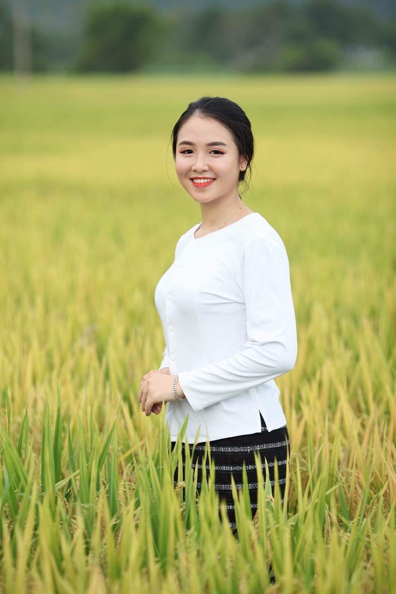 Trang phục truyền thống của phụ nữ dân tộc Thổ gồm áo trắng và váy kẻ sọc đen trắng