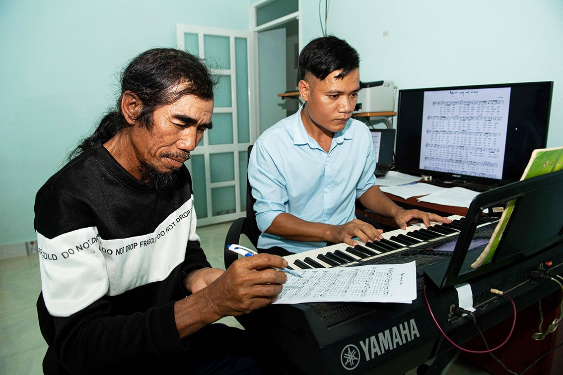 Anh A Thuê đang soạn nhạc cùng ông của mình là Nghệ nhân Ưu tú A Thui Anh A Thuê đang soạn nhạc cùng ông của mình là Nghệ nhân Ưu tú A Thui