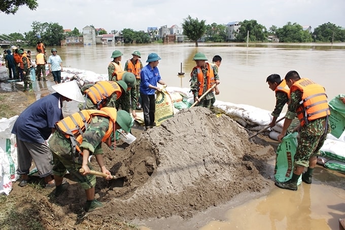 Các chiến sĩ quân đội cùng người dân tham gia hộ đê 