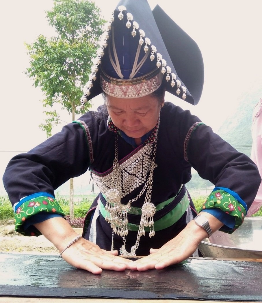 Nghệ nhân Pờ Chin Dín (thôn Chúng Chải B, thị trấn Mường Khương) hướng dẫn chị em thực hiện công đoạn trang trí cho chiếc mũ