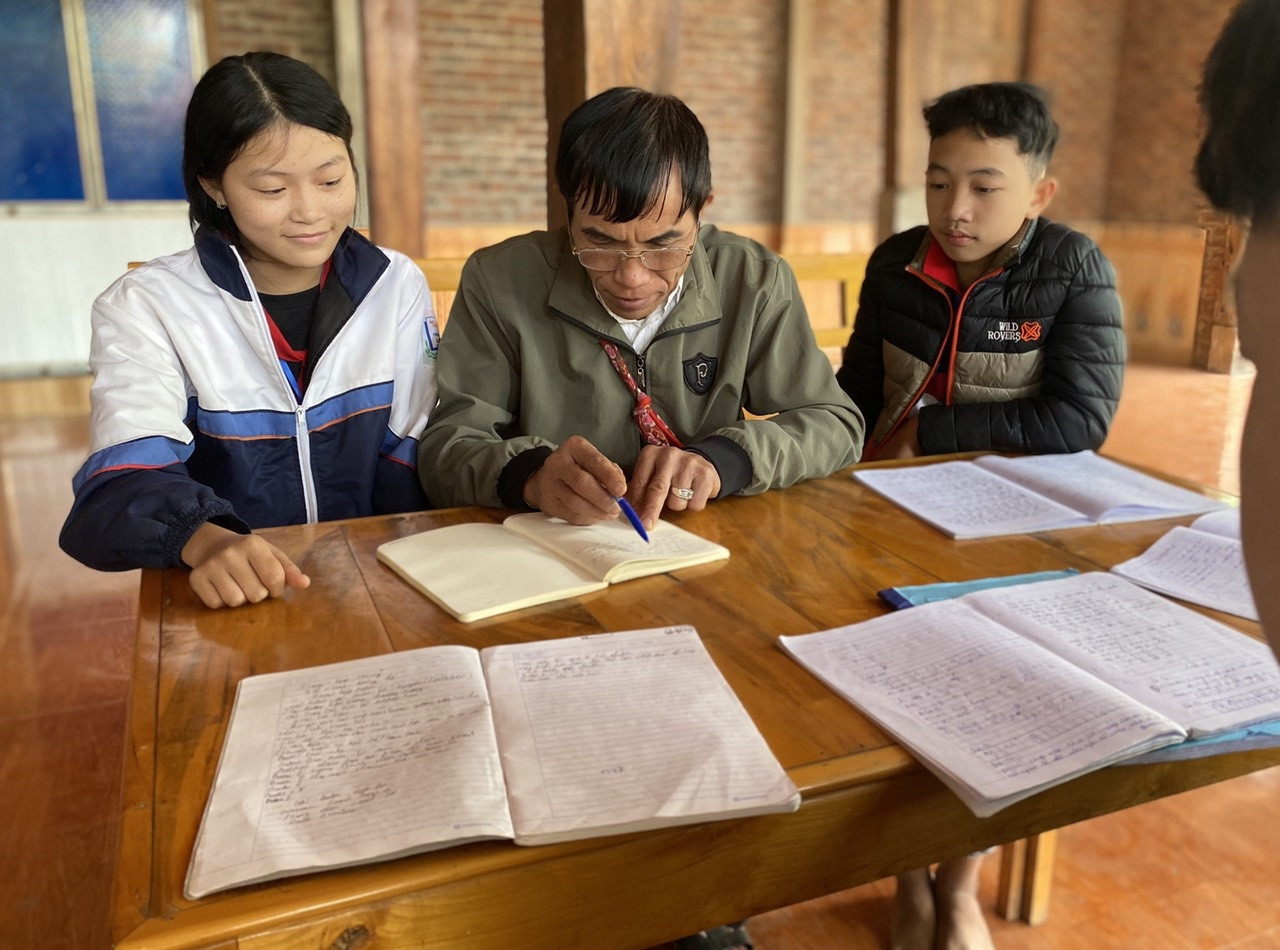Hằng ngày, có thời gian rảnh rỗi, ai có nhu cầu học về chữ Thái cổ ông đều tận tình hướng dẫn chỉ bảo (Trong ảnh: Ông Khay đang dạy chữ Thái cổ cho các cháu)