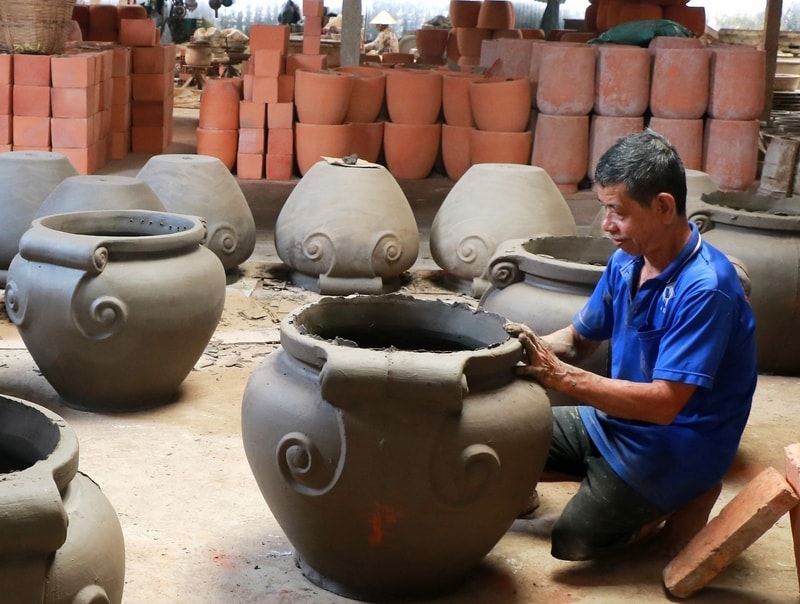 Ông Nguyễn Văn Mười Em đang chăm chút hoàn thiện tác phẩm của mình