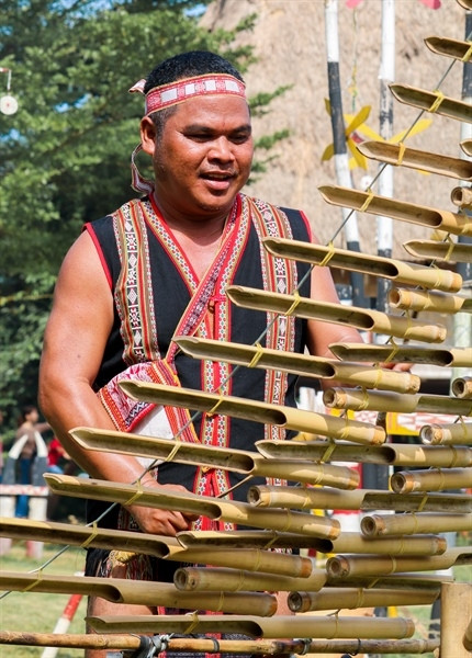Người đàn ông thì chơi nhạc cụ để gọi Yang sri về với buôn làng