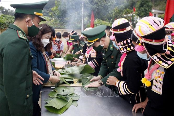 BĐBP cùng với bà con nhân dân xã Huổi Luông, huyện Phong Thổ gói bánh chưng xanh tặng cho hộ nghèo. 