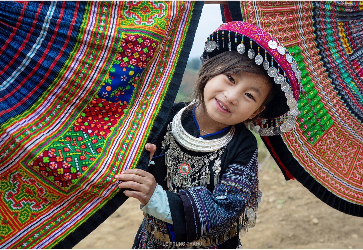 Em bé người Mông  ở La Pán Tẩn, huyện Mù Cang Chải, tỉnh Yên Bái  lấp ló sau chiếc váy hoa mới đang hong nắng