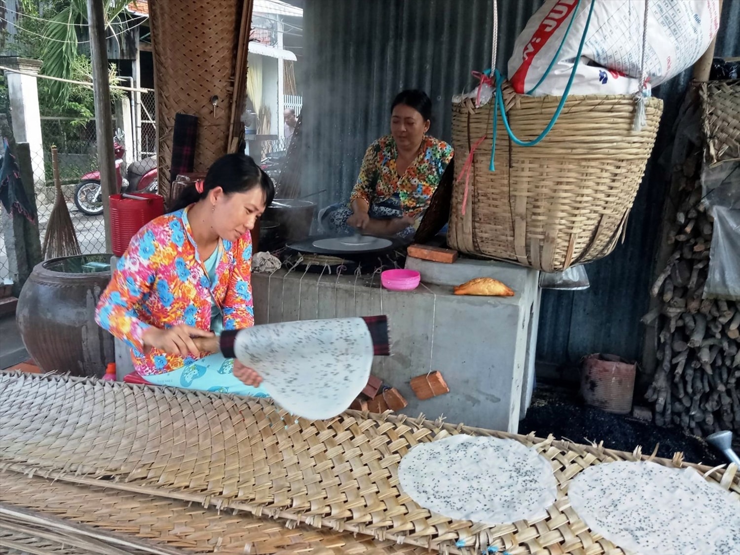 Chị Huỳnh Kim Nhã ở ấp Nghĩa Huấn, xã Mỹ Thạnh (huyện Giồng Trôm, Bến Tre) đang thao tác công đoạn tráng bánh và phơi lên phên.