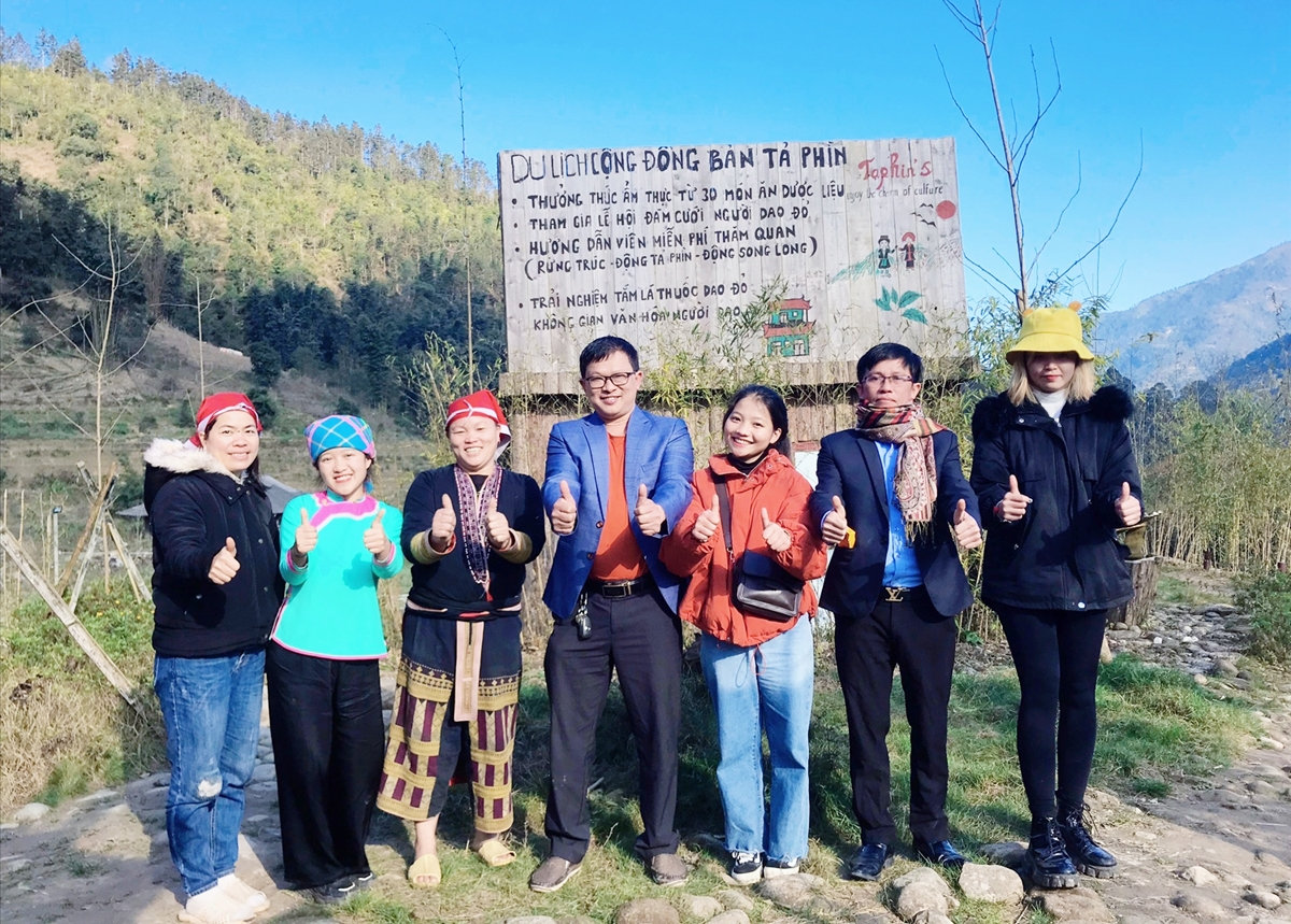 Vũ Thị Ngọc Hướng (thứ hai từ trái sang) chụp ảnh kỷ niệm cùng đoàn trong chuyến tham quan tại bản Tả Phìn