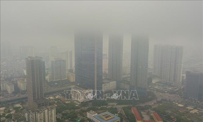 Tòa tháp Keangnam trên đường Phạm Hùng (quận Nam Từ Liêm) bị mưa phùn và sương phủ kín, không thể nhìn thấy nóc. Ảnh tư liệu: Thành Đạt/TTXVN