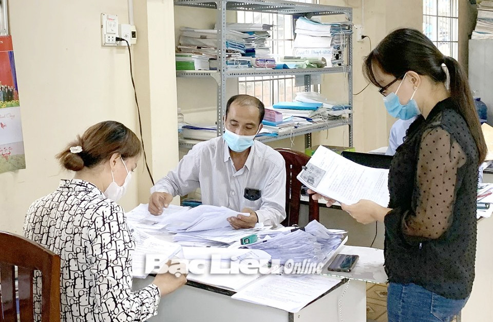 Cán bộ xã Hưng Hội (huyện Vĩnh Lợi) thực hiện các bước thủ tục trợ cấp cho người dân bị ảnh hưởng bởi dịch Covid-19. (Ảnh: H.T)