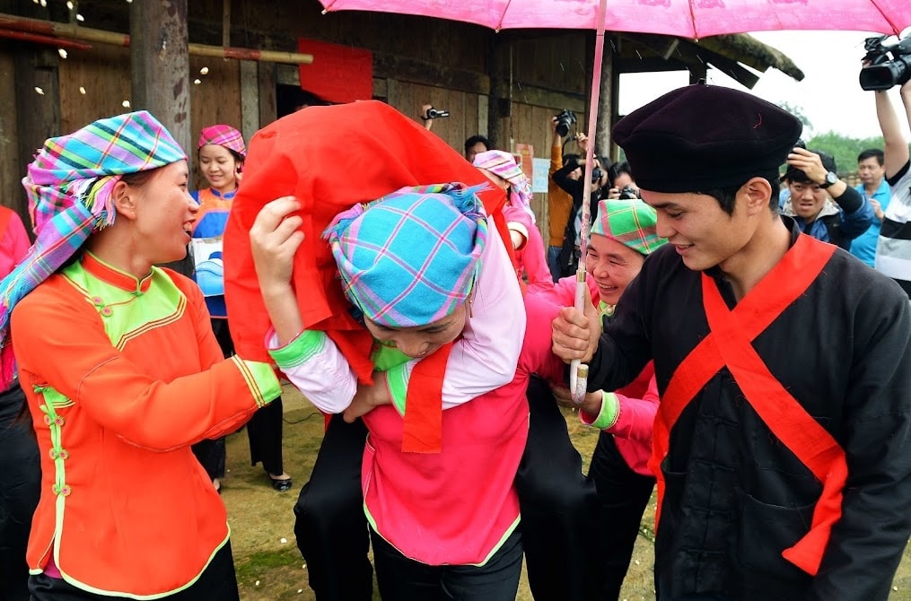 Nhà trai cử một người phụ nữ to khỏe cõng cô dâu về nhà trai.