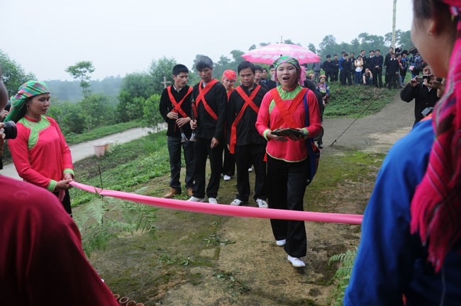 Nghi thức bà mối trao “lì xì” để xin phép vào nhà gái. Sau khi đã làm lễ giữ, nhà trai phải trải qua một tục lệ khác rất thú vị. Đó là phải hát đối đáp để xin nhà gái bỏ tấm vải hồng chắn ngay đường vào. Khi vào nhà, nhà gái đem phẩm đỏ đánh dấu lên má từng người của nhà trai.