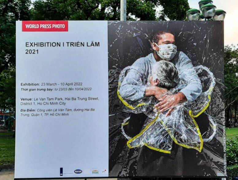 Bức ảnh Cái ôm đầu tiên (The First Embrace) của nhiếp ảnh gia người Đan Mạch Mads Nissen được đặt tại lối ra vào triển lãm. Bức ảnh Cái ôm đầu tiên (The First Embrace) của nhiếp ảnh gia người Đan Mạch Mads Nissen được đặt tại lối ra vào triển lãm.