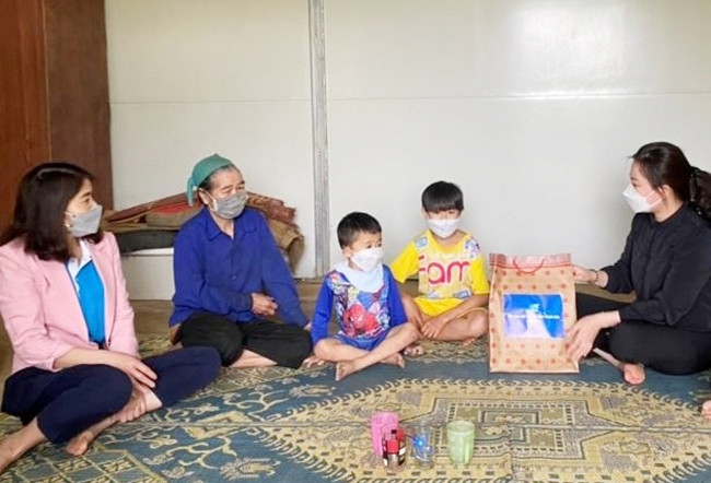 Đại diện lãnh đạo Hội LHPN tỉnh, huyện và xã tặng quà cho trẻ mồ côi ở bản Táo