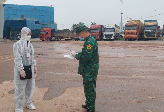 Lực lượng Biên phòng kiểm tra các điều kiện bảo đảm an toàn phòng, chống dịch và xuất nhập cảnh đối với các lái xe trung chuyển. (Ảnh: Hữu Việt)