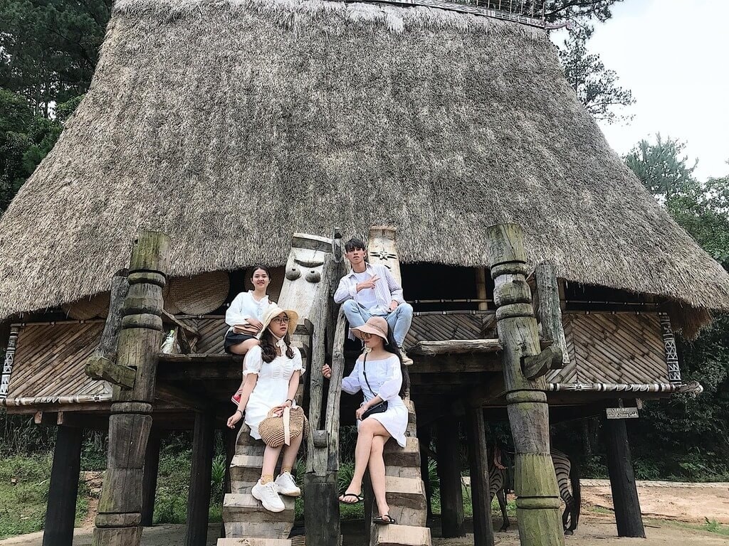 Du khách chụp ảnh check in với nhà Rông của đồng bào Cơ Ho.