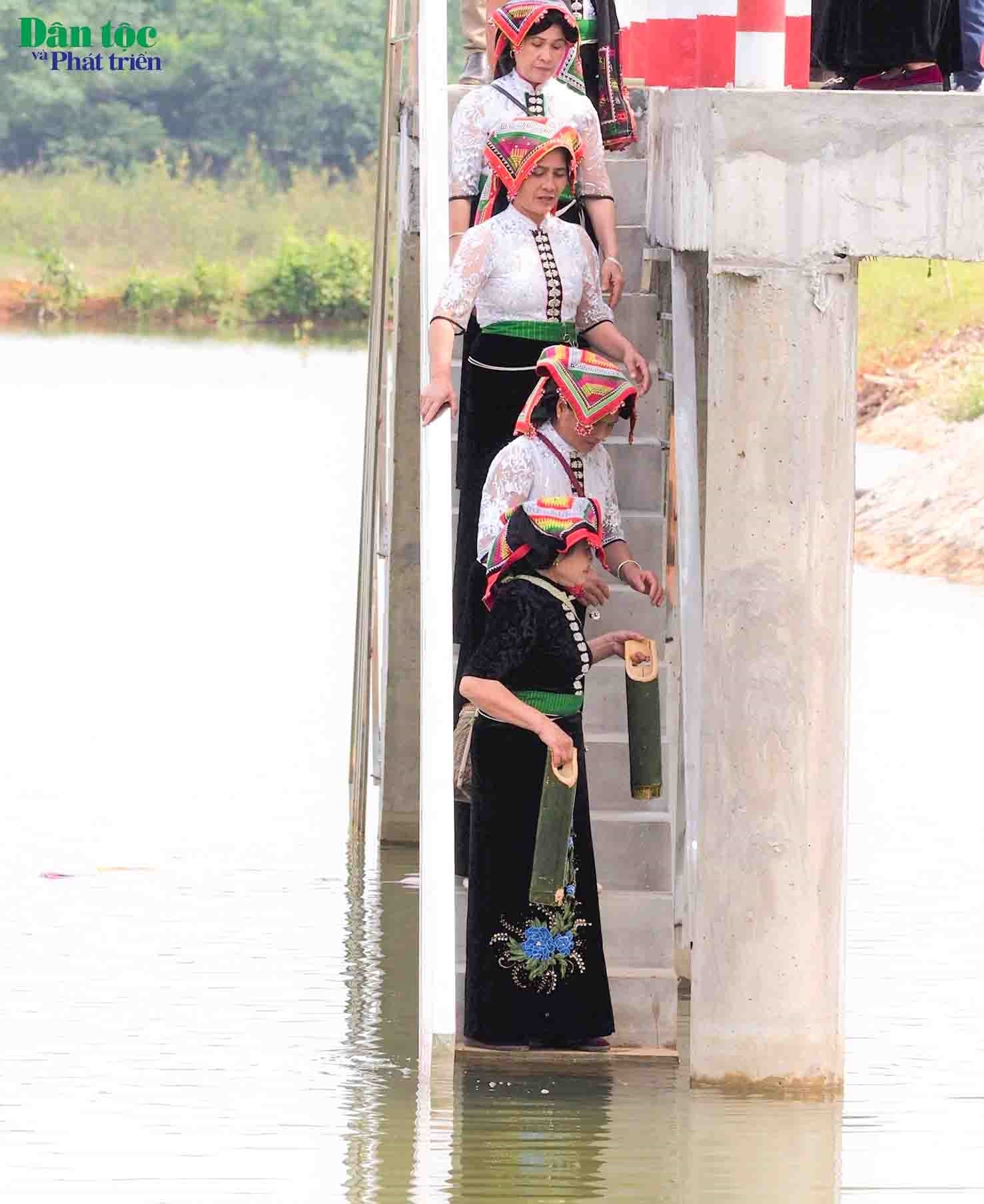 Sáng sớm hôm đó, khi mặt trời ló rạng, thầy cúng sẽ dẫn một bà góa trong bản quẩy đôi gánh buộc những ống bương đựng nước đi tới từng nhà gọi chị em phụ nữ cùng ra mó nước. Bà góa cùng các chị em độ tuổi trung niên trong bản ra mó nước thực hiện lễ với thổ địa và thần linh- nghi lễ đầu tiên của Lễ cầu mưa và xin phép gánh nước về