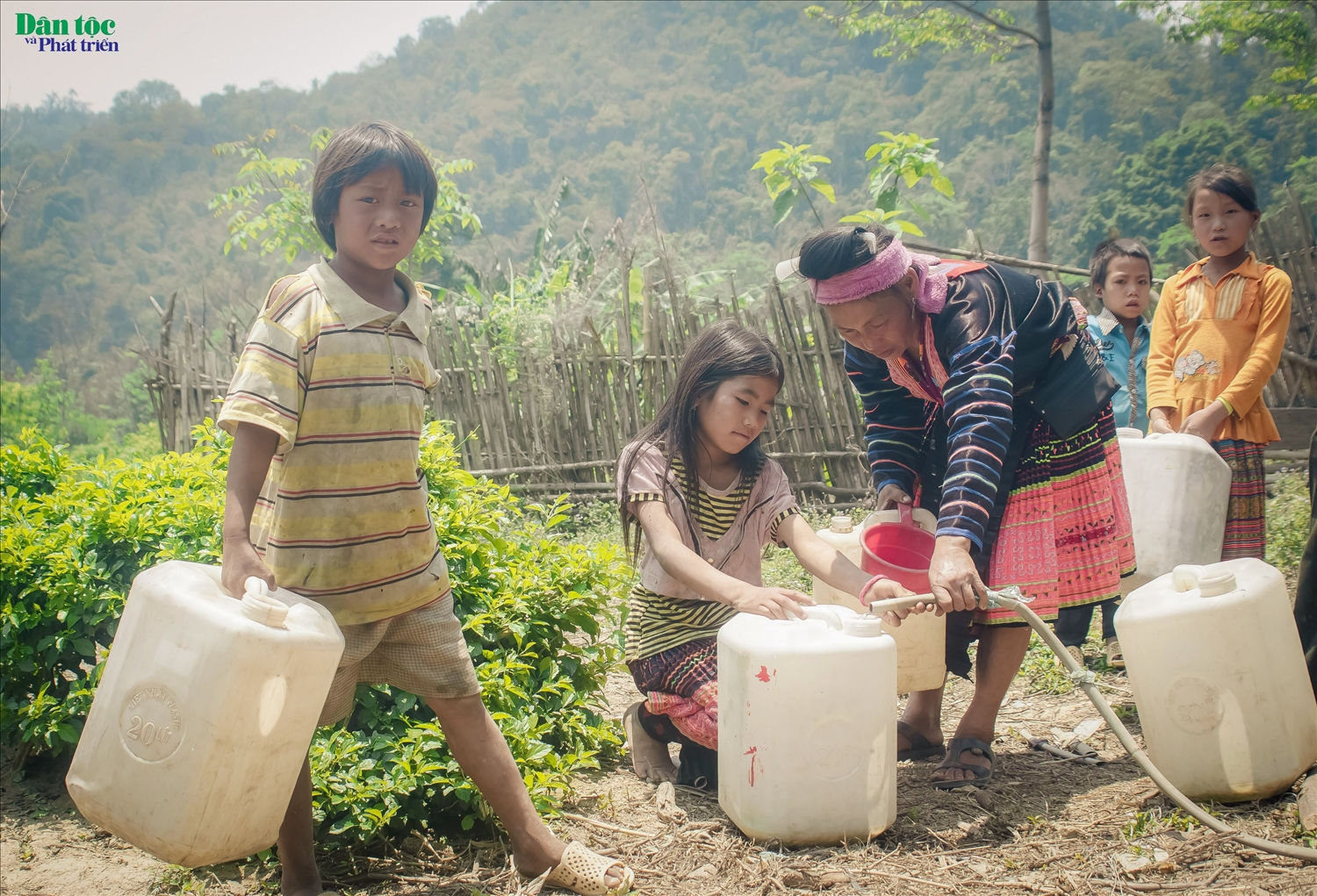 Các em bé người Mông cũng phụ mẹ xách nước dùng trong sinh hoạt hằng ngày