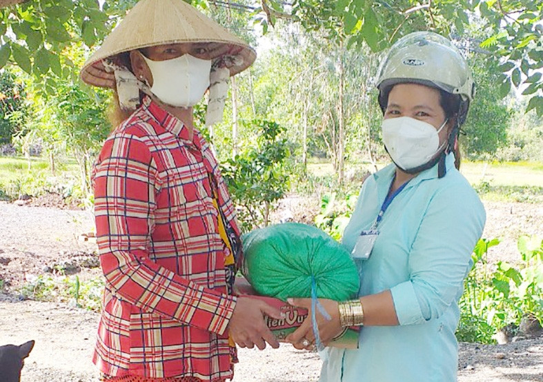 Chị Trần Kim Ly (bên phải) tặng quà cho người nghèo bị ảnh hưởng bởi dịch Covid-19