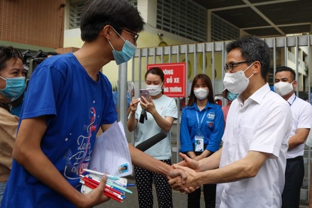 Phó Thủ tướng Vũ Đức Đam chúc mừng những thí sinh đầu tiên hoàn thành môn Văn ở điểm thi Trường THCS Nghĩa Tân - Ảnh: VGP/Đình Nam