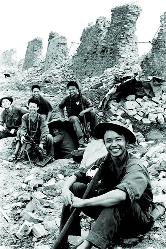 Cựu chiến binh Lê Xuân Chinh (người ngồi đầu) trong tấm ảnh “Nụ cười chiến thắng bên Thành cổ Quảng Trị”
