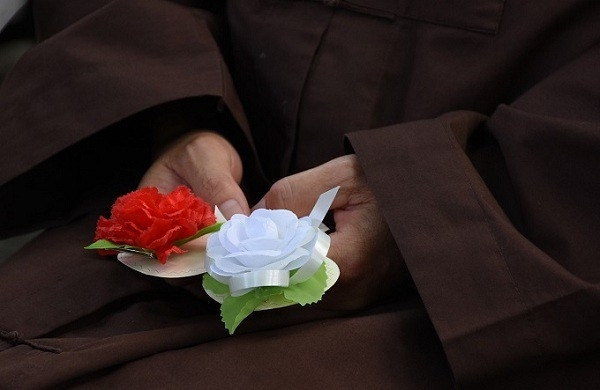 Bông hoa màu hồng cài trên áo với ý nghĩa con vẫn còn mẹ, bông hoa màu trắng tượng trưng cho nỗi nhớ khôn nguôi về người mẹ đã khuất