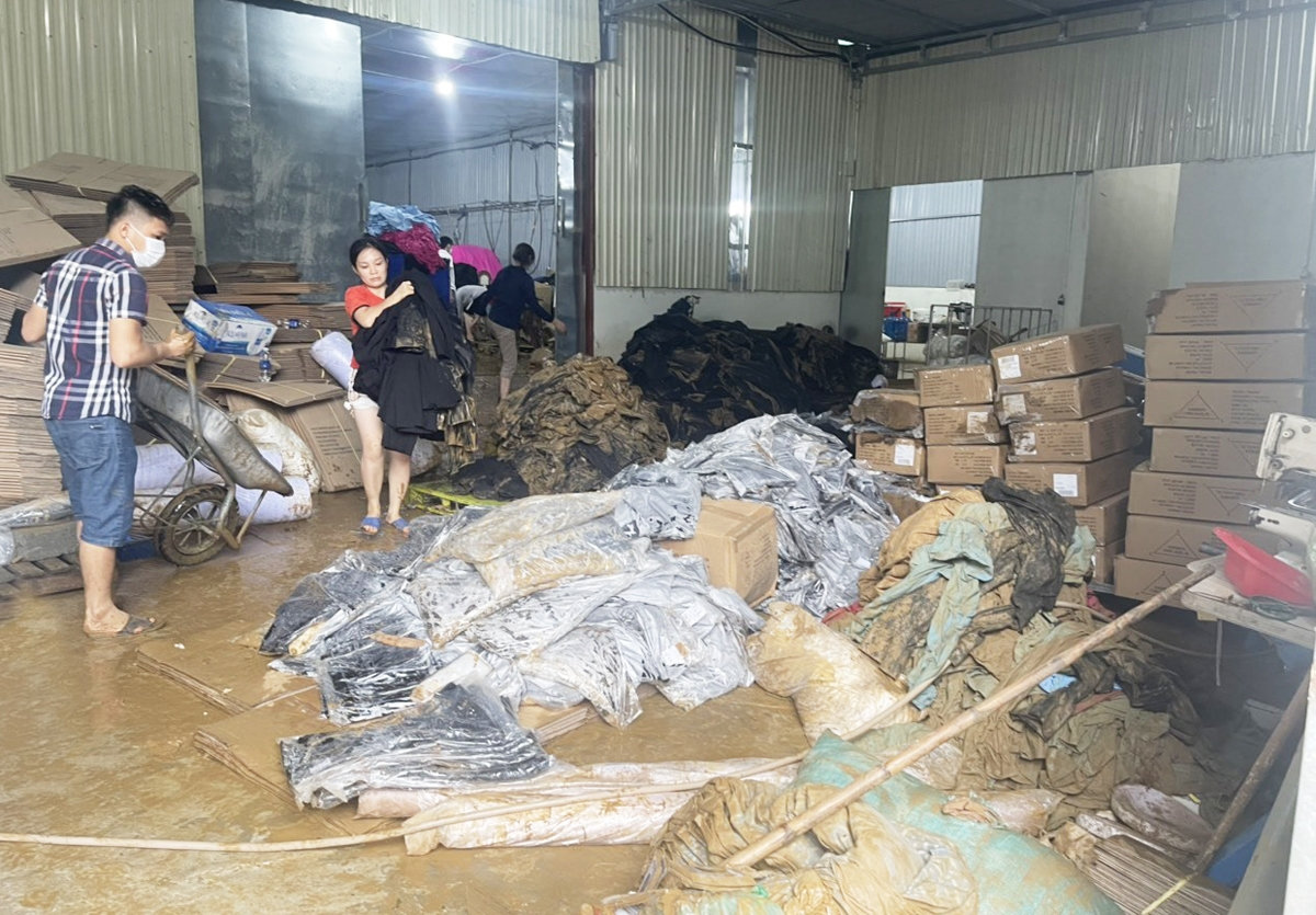 Công nhân Công ty may 3T VINA khắc phục hậu quả sau mưa lũ. (Ảnh: ĐVCC)
