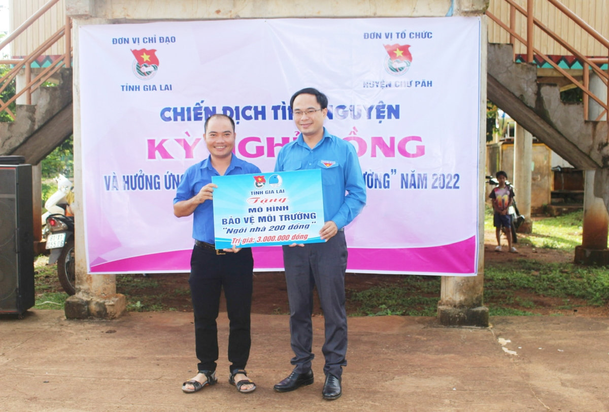 Anh Đỗ Đức Thanh - Phó Bí thư Tỉnh đoàn Gia Lai tặng bảng tượng trưng ngôi nhà 200 đồng bảo vệ môi trường cho Đoàn thị trấn Ia Ly 