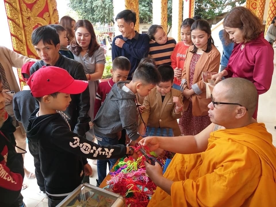 Du khách buộc chỉ tau cầu may ở chùa Ka Ron, Lào Du khách buộc chỉ tau cầu may ở chùa Ka Rôn, Lào