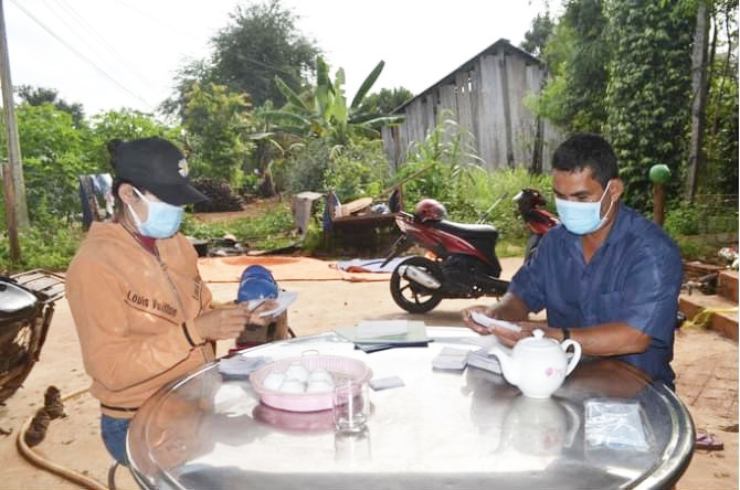 Anh Điểu Cần - Trưởng thôn Thiện Cư (Bù Đốp) giúp dân giải quyết thủ tục hành chính bất kể ngày đêm. (Ảnh: Trần Trung)