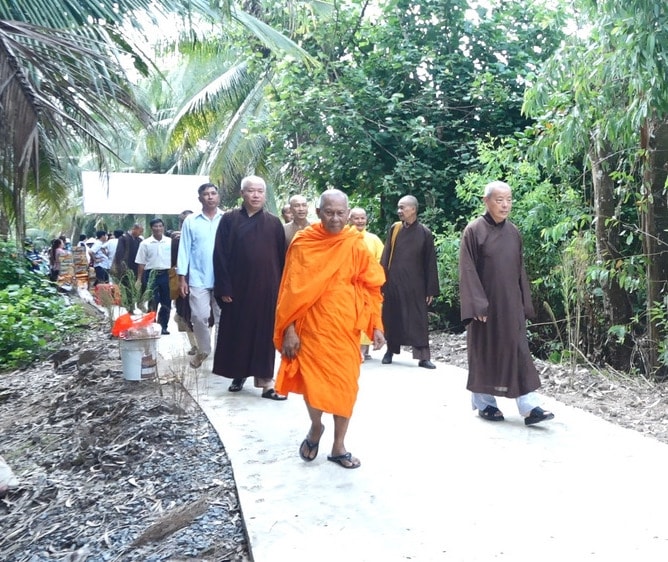 Hoà Thượng Thạch Sok Xane, Hội trưởng Hội đoàn kết SSYN tỉnh Trà Vinh (người mặc áo cà sa) cùng mạnh thường quân trên con đường vừa khánh thành