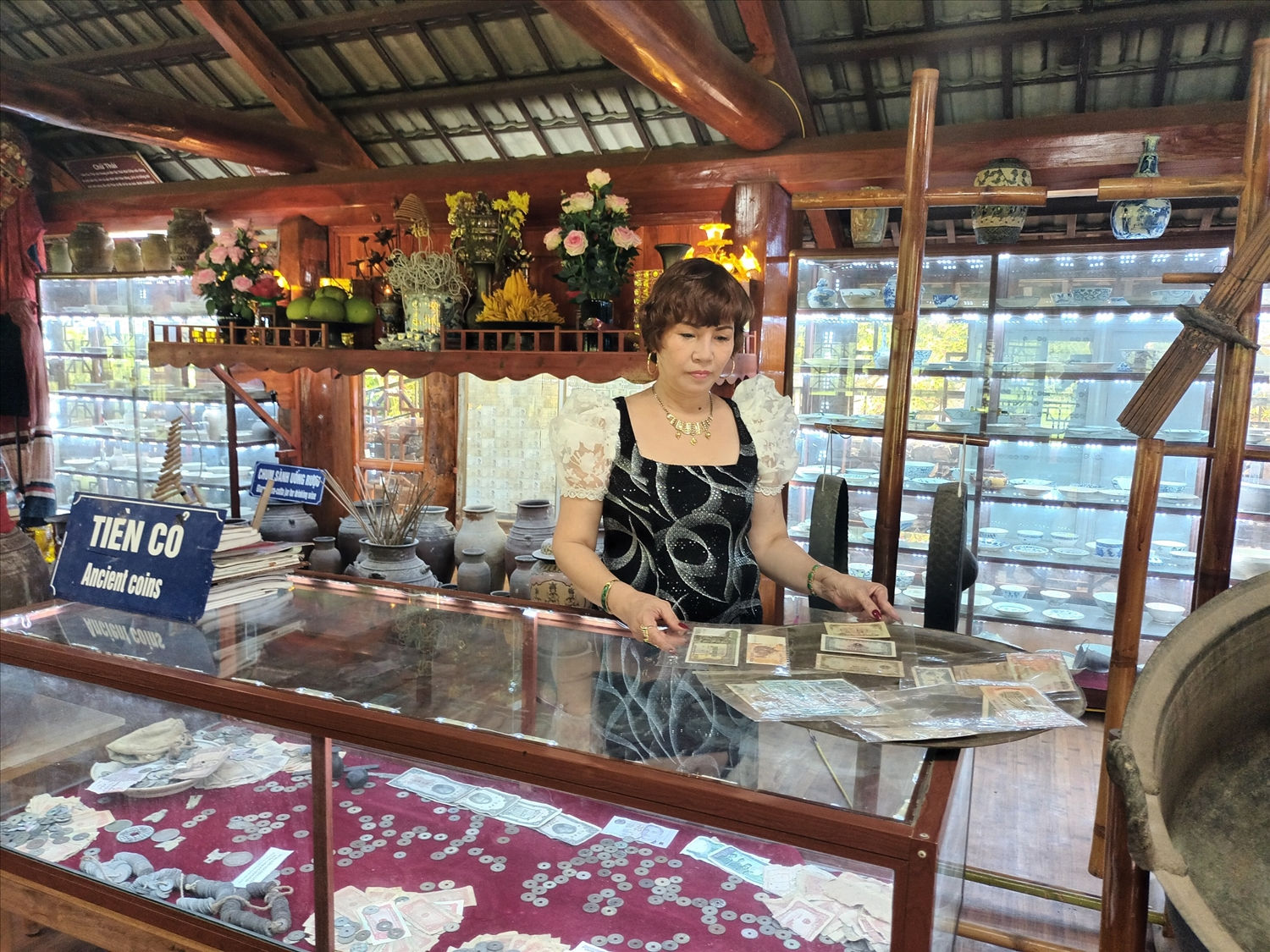 Chị Nguyễn Thị Tô Xuân bên bộ sưu tập tiền cổ tại Bảo tàng Thái Mai Châu Chị Nguyễn Thị Tô Xuân bên bộ sưu tập tiền cổ tại Bảo tàng Thái Mai Châu