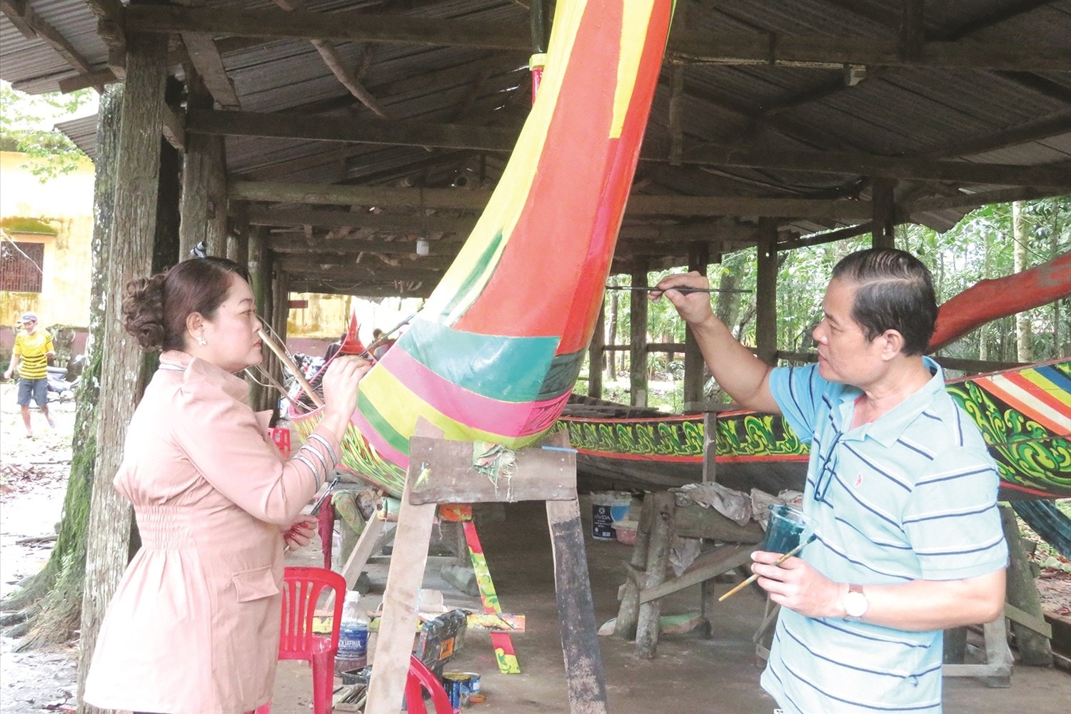  Vợ chồng nghệ nhân Lâm Phiên và Sơn Sà The hoàn thành những nét vẽ cuối cùng của chiếc ghe ngo