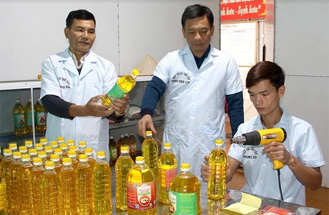 Ông Đàm Văn Việt, Chủ tịch Hội đồng Quản trị HTX Thái Sơn (đứng giữa) kiểm tra công đoạn đóng gói, dán tem sản phẩm dầu lạc đỏ (Ảnh: Báo Yên Bái) Ông Đàm Văn Việt, Chủ tịch Hội đồng Quản trị HTX Thái Sơn (đứng giữa) kiểm tra công đoạn đóng gói, dán tem sản phẩm dầu lạc đỏ (Ảnh: Báo Yên Bái)