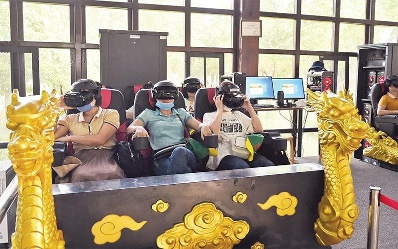 Du khách trải nghiệm dịch vụ giải trí sử dụng công nghệ thực tế ảo VR3D tại Di tích Cố đô Huế. (Ảnh DUY ÐĂNG)