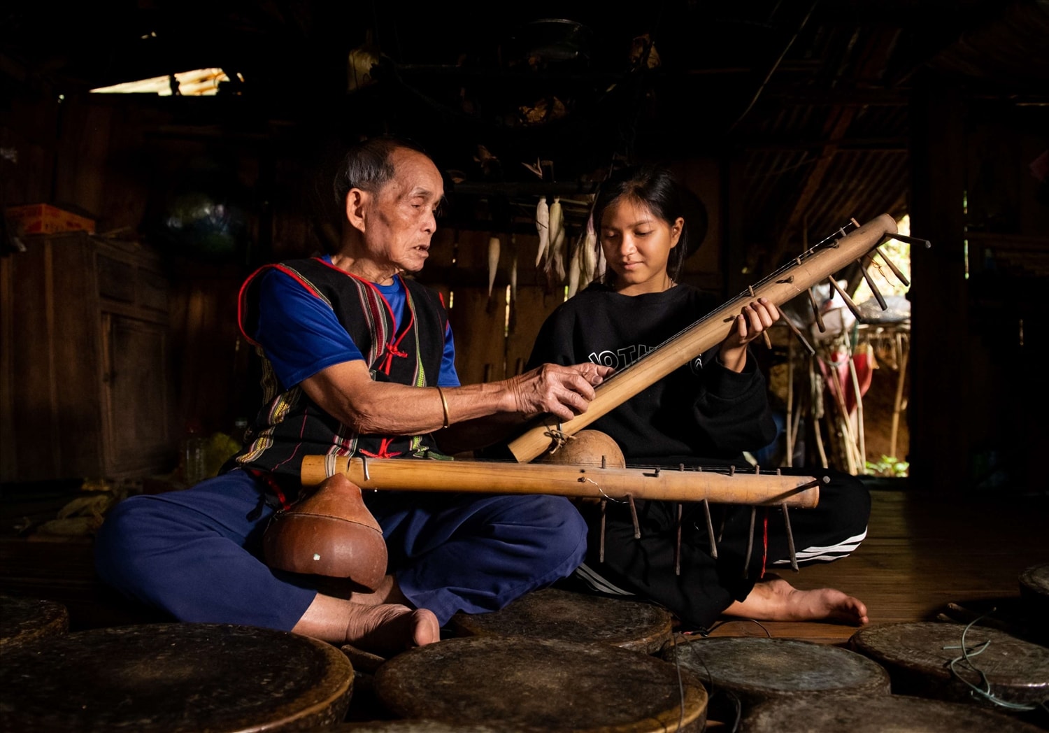 Nghệ nhân ưu tú A Né truyền dạy đàn ting ning cho chắt của ông. Ảnh: Đ.TNghệ nhân ưu tú A Né truyền dạy đàn ting ning cho chắt của ông. Ảnh: Đ.T