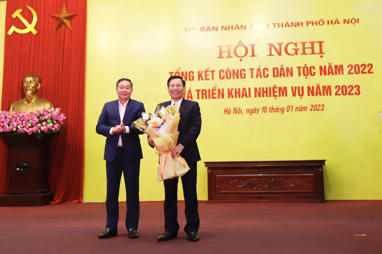 Phó Chủ tịch Thường trực UBND Thành phố Lê Hồng Sơn tặng hoa cho nguyên Trưởng ban Dân tộc TP. Hà Nội Nguyễn Tất Vinh