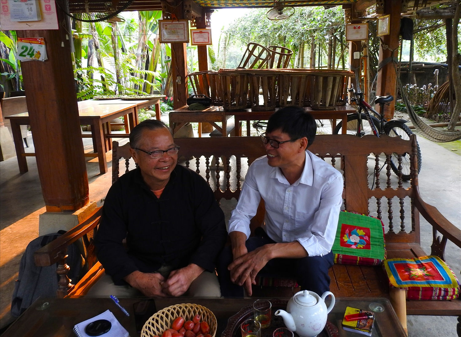 Người có uy tín Điêu Văn Khang (áo đen) bày tỏ niềm vui với cán bộ xã Nghĩa Lợi về mô hình Homestay của gia đình