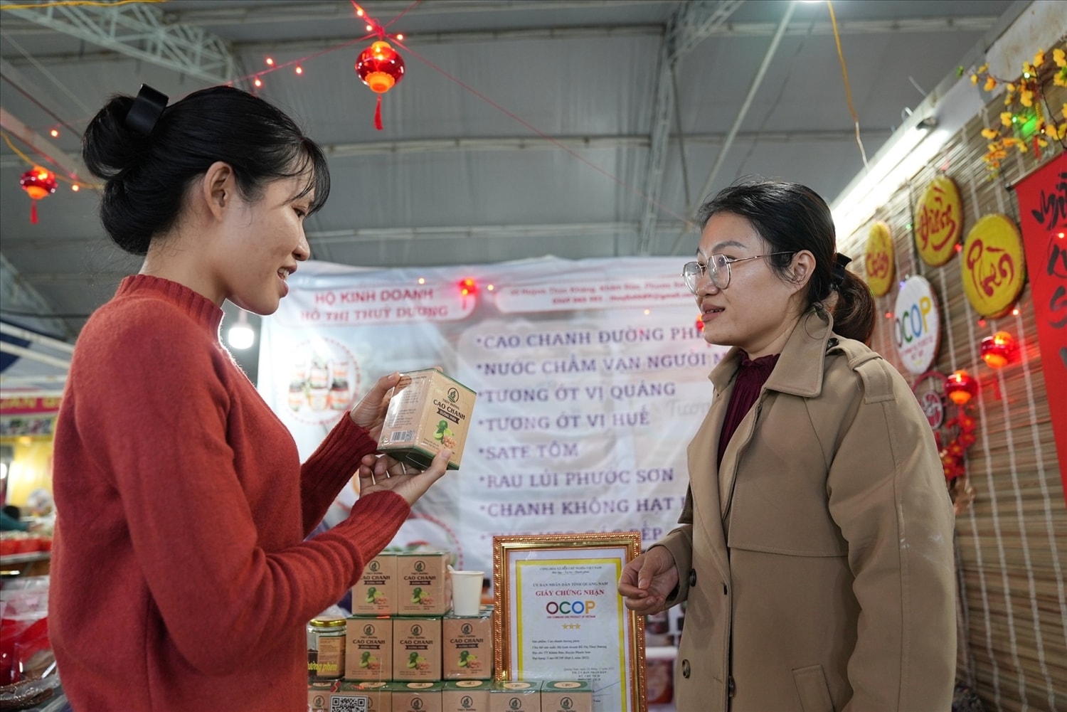 Chị Hồ Thị Thùy Linh (bên phải) giới thiệu sản phẩm cao chanh đường phèn mang tên Thùy Dương cho khách hàng. Ảnh: L.Q Chị Hồ Thị Thùy Linh (bên phải) giới thiệu sản phẩm cao chanh đường phèn mang tên Thùy Dương cho khách hàng. Ảnh: L.Q